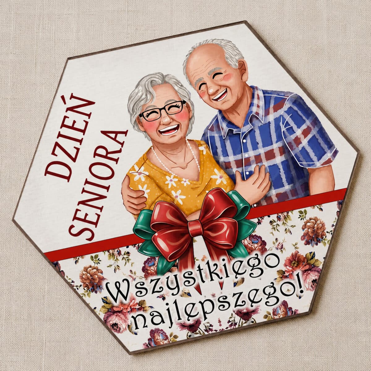 Upominek na Dzień Seniora z parą seniorów, dekoracyjną kokardą, kwiatami i życzeniami